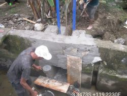 Petani dan Petugas Pasang Pintu Air Tersier di Saluran Irigasi Lakejo