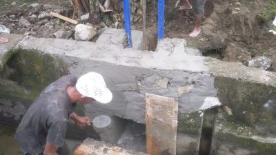 Petani dan Petugas Pasang Pintu Air Tersier di Saluran Irigasi Lakejo
